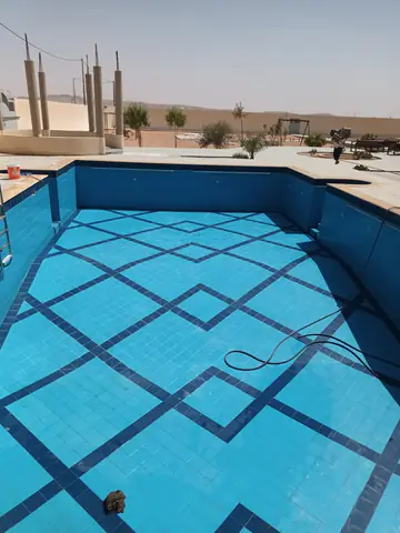 مسبح فارغ مبلّط بالأزرق في موقع عمل
