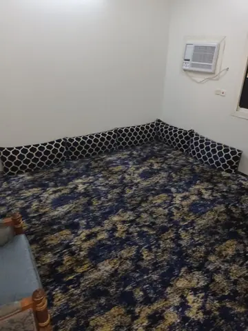سجادة زرقاء مزخرفة مفروشة على أرضية غرفة بيضاء