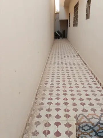 ممر ضيق مبلّط ببلاط مزخرف بين جدارين